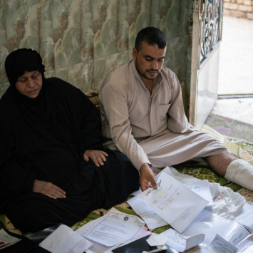 Hameeda e seu filho examinam seus arquivos médicos. Foto por: Chloe Sharrock / MSF